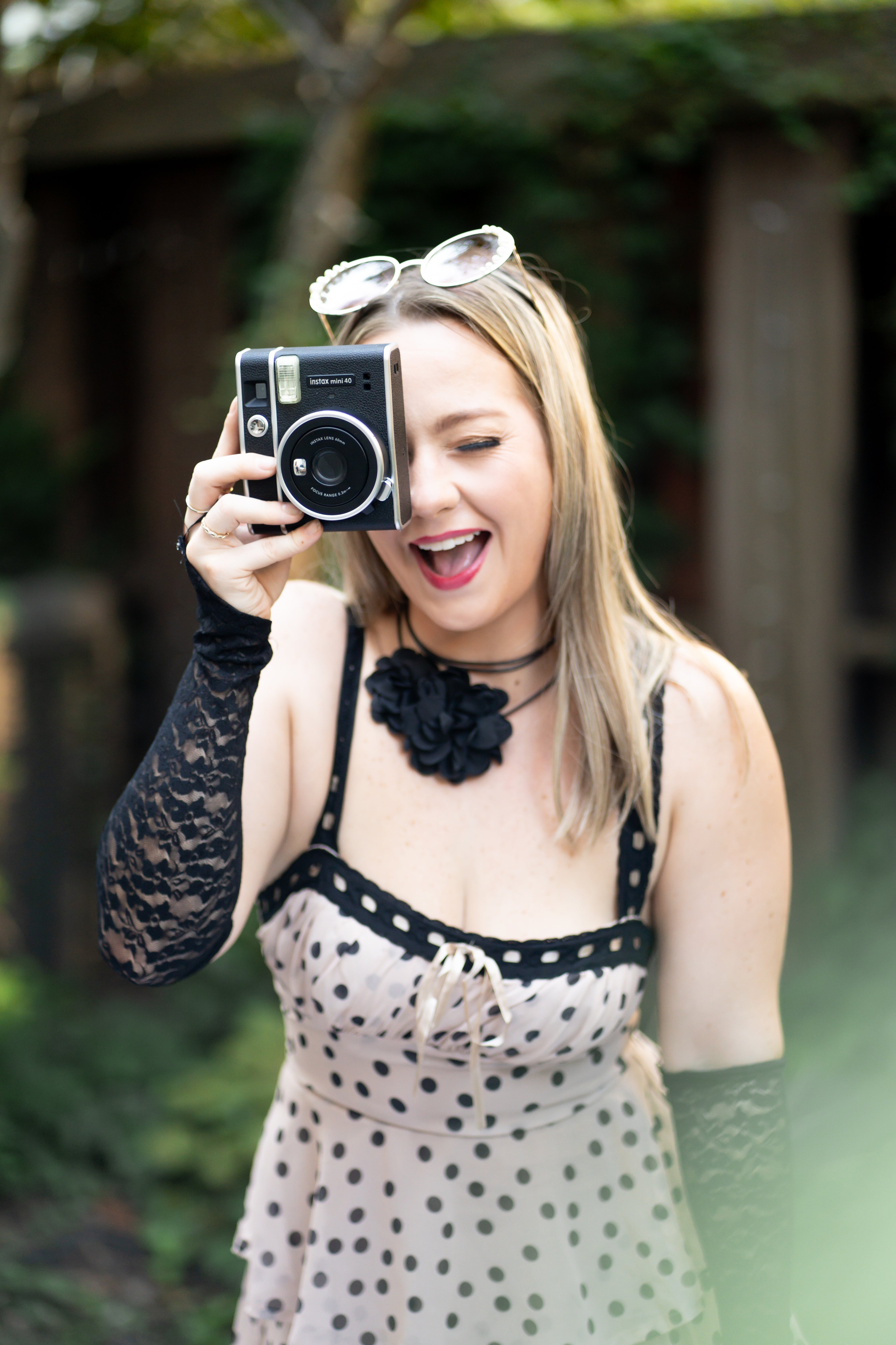 Woman holding a vintage camera outdoors with a blurred background