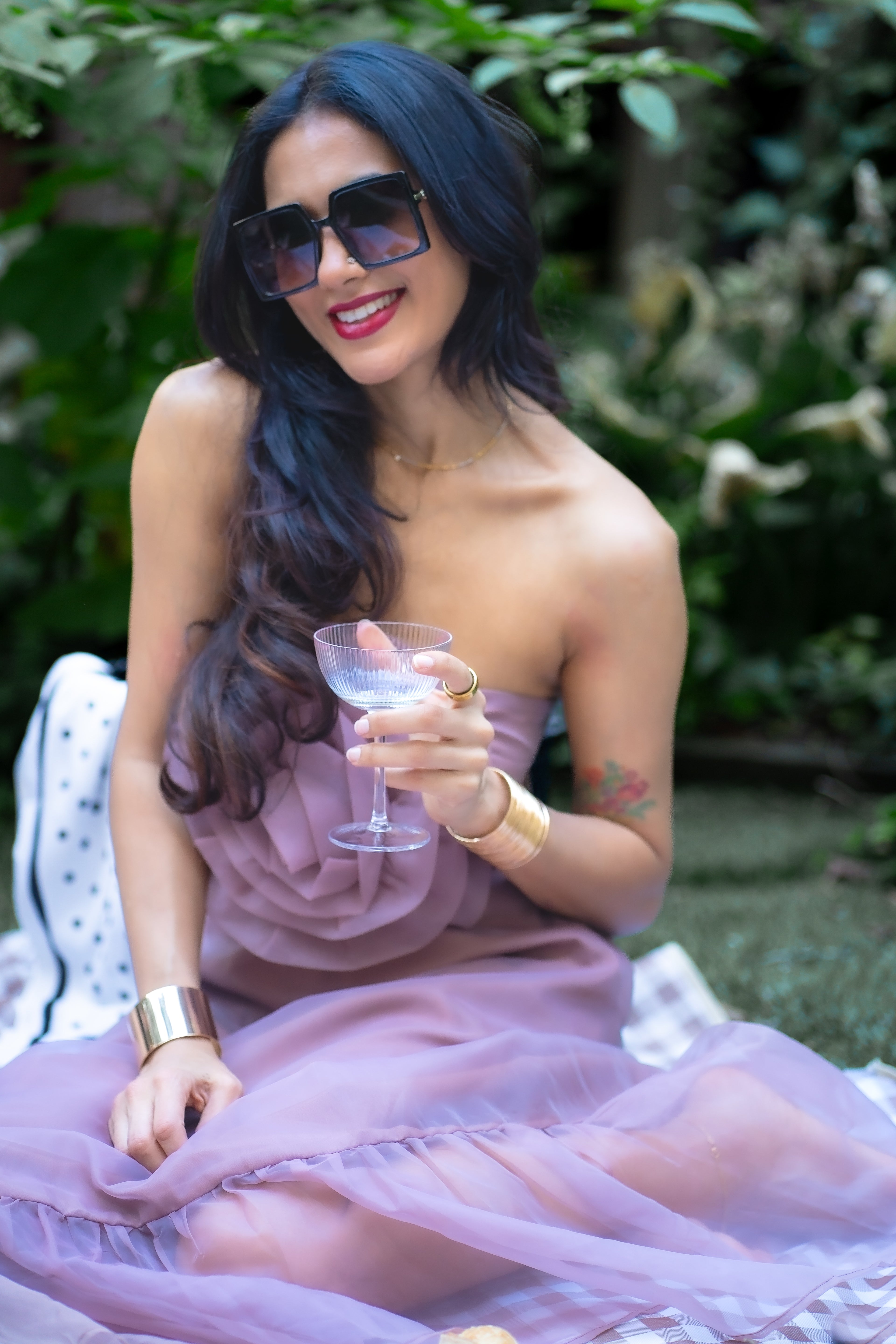 Woman in a pink dress holding a glass outdoors