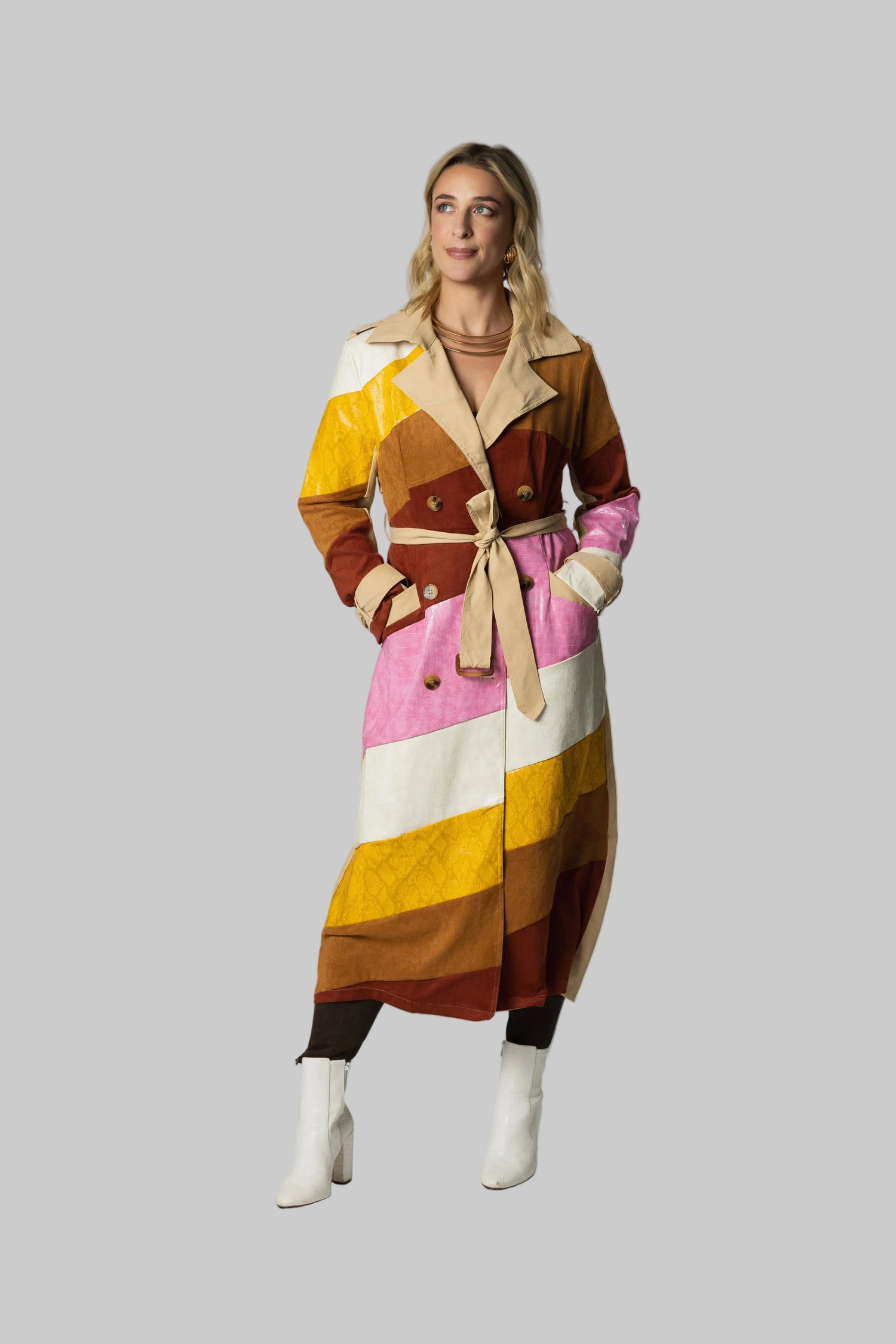 Woman wearing a colorful striped coat on a plain background