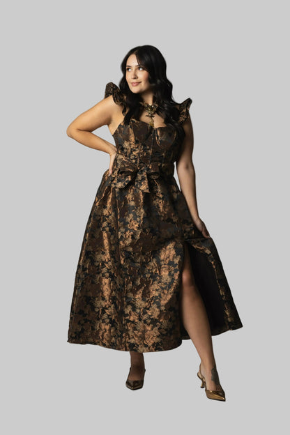 Woman wearing a brown patterned dress on a gray background